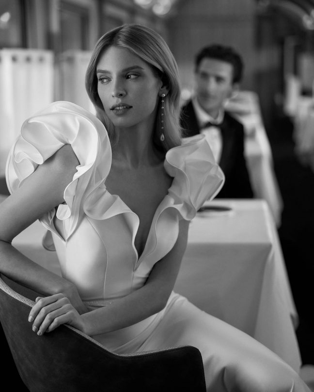 Modelo Violeta - Vestido de novia largo, de corte sirena y estilo elegante, elaborado con mikado elástico. Presenta un escote en V, una espalda abierta y manga con volantes. Un exclusivo modelo Aire Barcelona. tiendas de vestidosd e novia en Toledo cita en El Clavel
